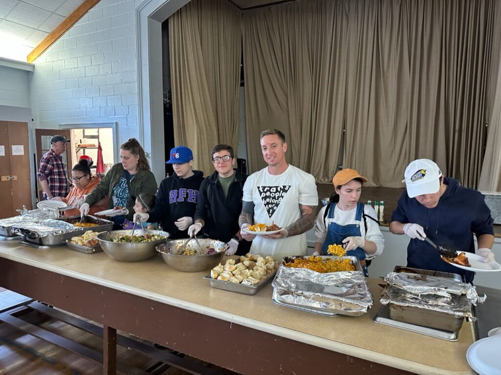 Photo of a volunteers lined up and ready to serve a community meal